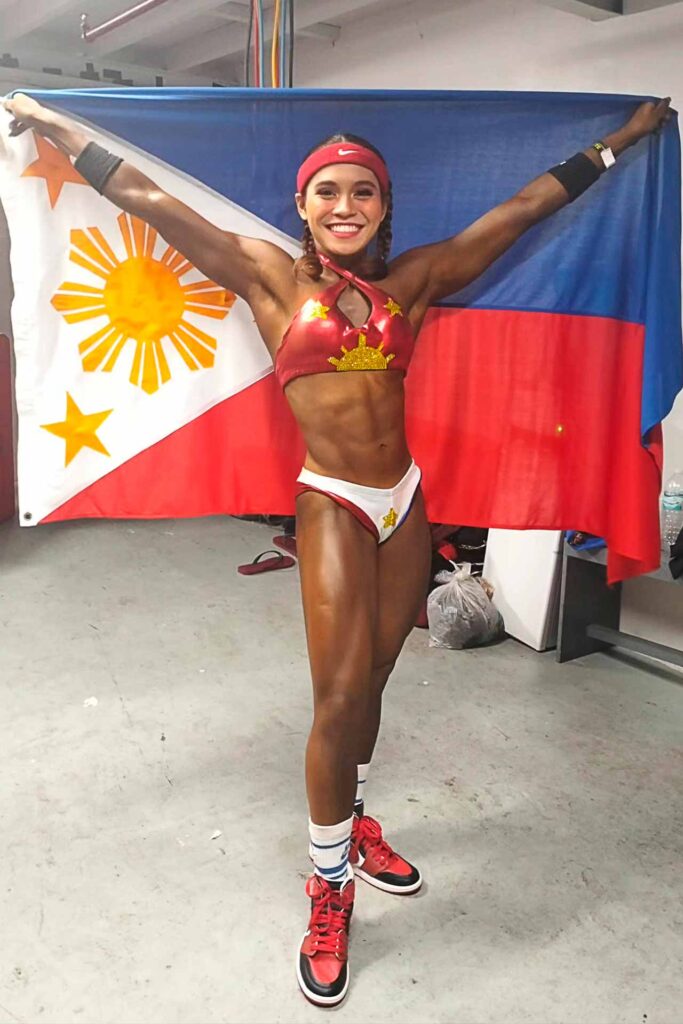 Julianna Nicole Lopez holding the Philippine flag after an international fitness competition