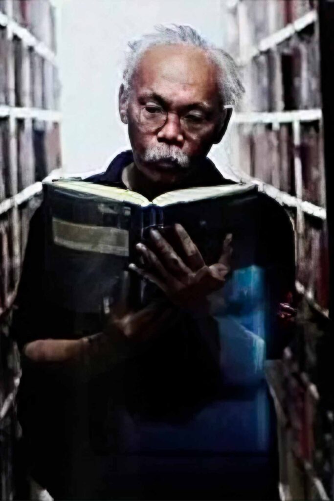 César Ruiz Aquino reading a book in a library