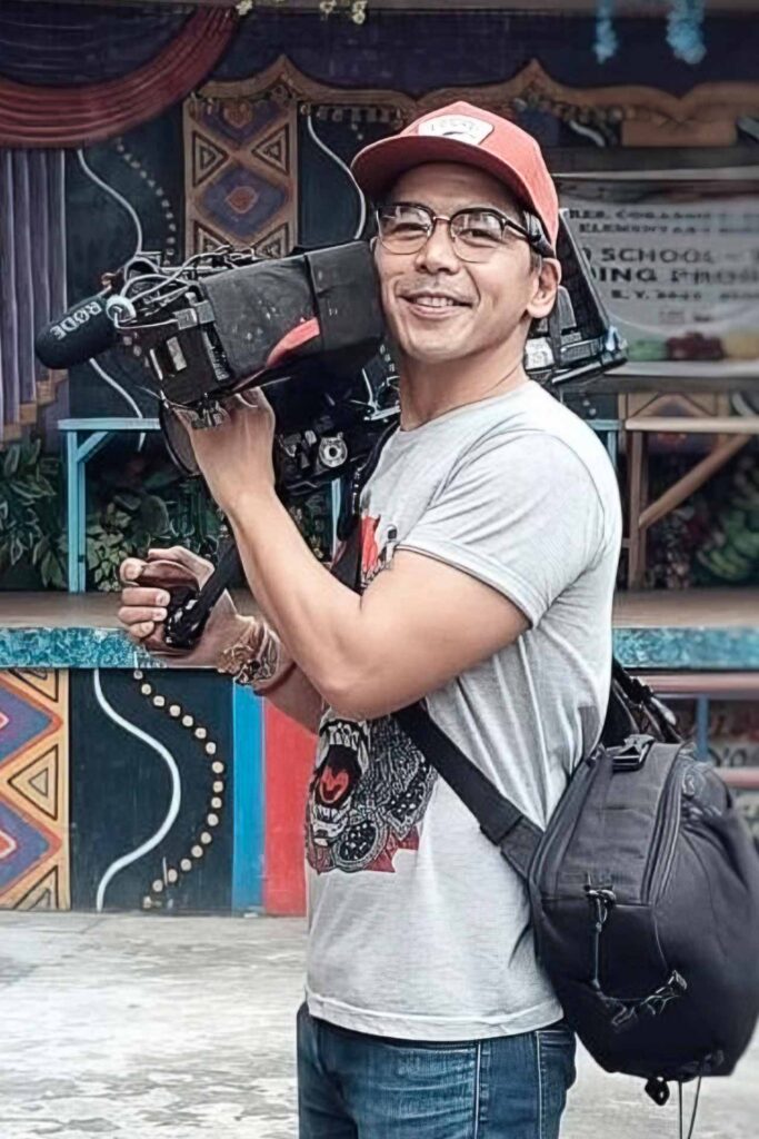 JR Dalisay holding a professional video camera during an outdoor shoot
