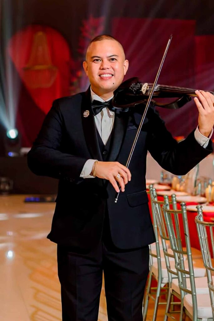 John Lester Barot performing on the violin during a formal event