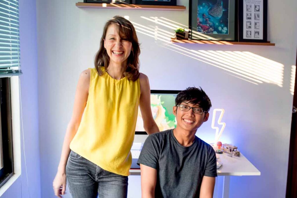 Evgeniya Spiridonova (left) standing beside Filipino artist Alex Jusay (right) in his creative workspace