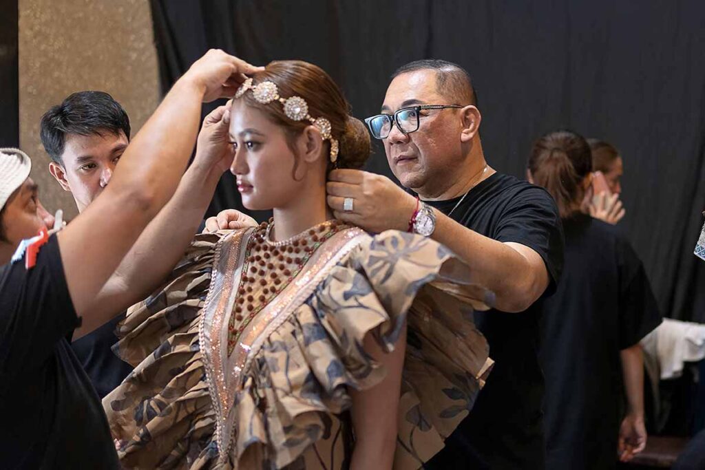 Amir Sali preparing a model backstage before the fashion show