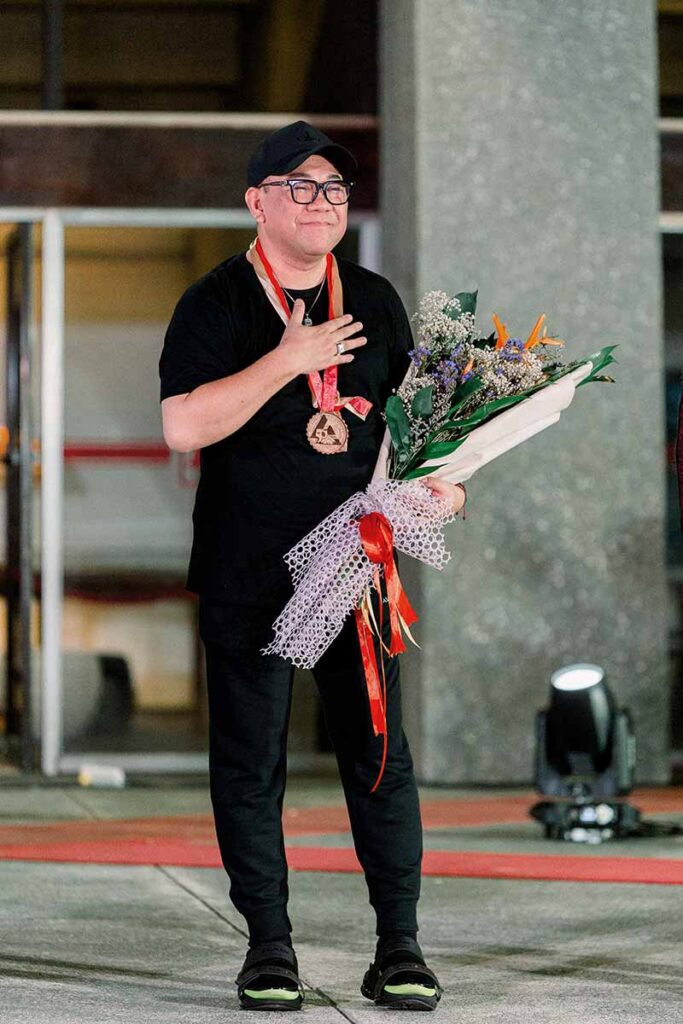 Fashion designer Amir Sali holding flowers after the fashion show