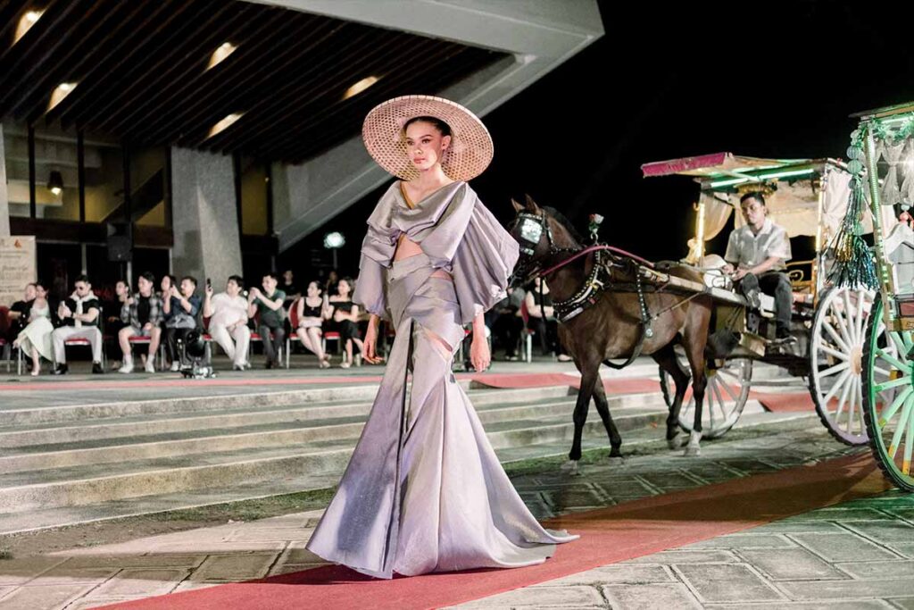 Model wearing a silver-gray Filipino-inspired dress by Josip Tumapa with a wide woven hat