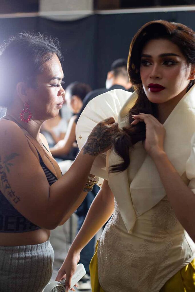 Josip Tumapa preparing a model backstage before the runway show