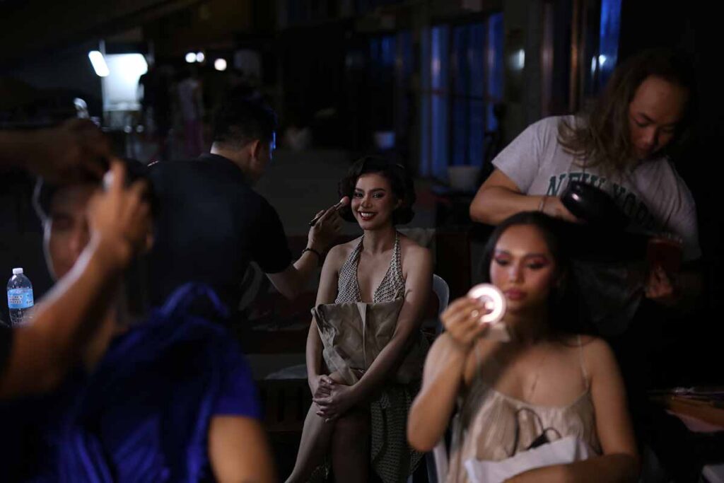 Models having makeup and hair done backstage before the fashion show