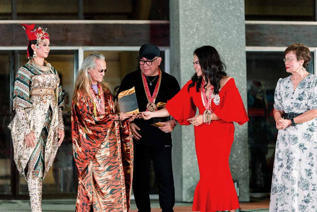 Designers Tingting Delfin, Amir Sali and Josip Tumapa together on the runway after the fashion show
